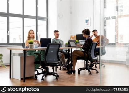 business, people and corporate concept - team of startuppers or designers working at office. business team or startuppers working at office