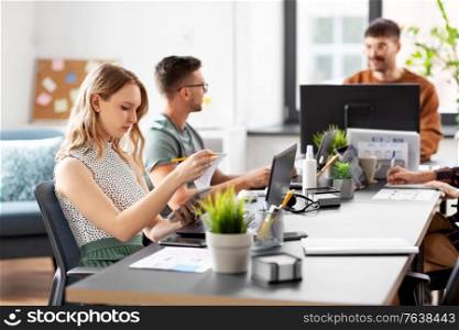 business, people and corporate concept - team of startuppers or ui designers working at office. business team or startuppers working at office