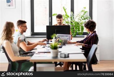 business, people and corporate concept - team of startuppers or ui designers working at office. business team or startuppers working at office