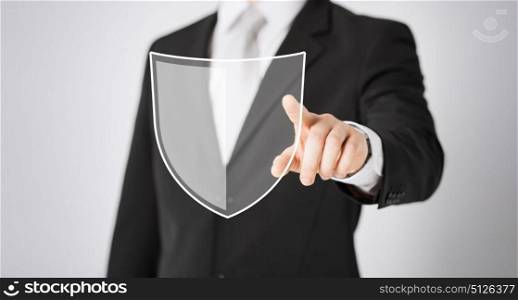 business, people and cyber protection concept - close up of man pointing his finger at virtual antivirus program shield icon over gray background. man pointing finger at antivirus program icon