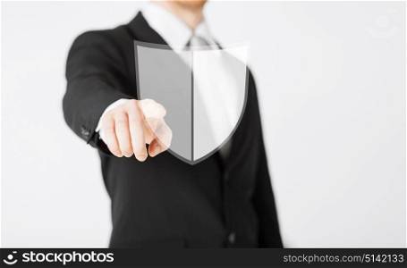 business, people and cyber protection concept - close up of man pointing his finger at virtual antivirus program shield icon. man pointing finger at antivirus program icon