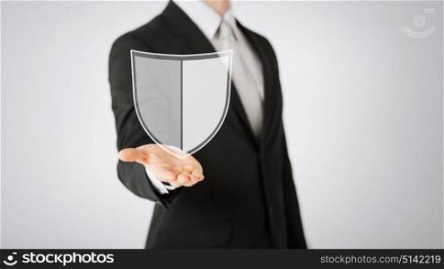 business, people and cyber protection concept - close up of man with virtual antivirus program shield icon over gray background. man with virtual antivirus program icon