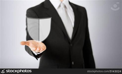 business, people and cyber protection concept - close up of man with virtual antivirus program shield icon over gray background. man with virtual antivirus program icon
