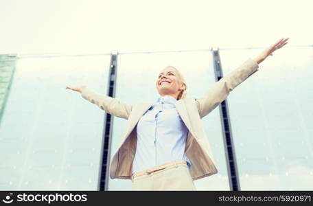 business, people and education concept - young smiling businesswoman over office building