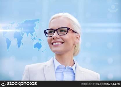 business, people and education concept - young smiling businesswoman with world map hologram outdoors