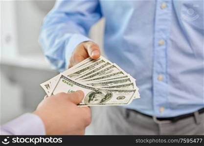 business, people and finances concept - close up of businessmen&rsquo;s hands holding american dollar money. close up of businessmen&rsquo;s hands holding money