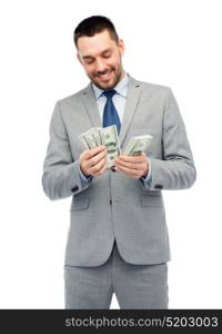 business, people and finances concept - smiling businessman counting american dollar money. smiling businessman counting american dollar money