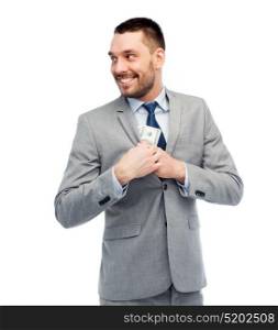business, people and finances concept - smiling businessman hiding american dollar money into jacket pocket. businessman hiding money into jacket pocket
