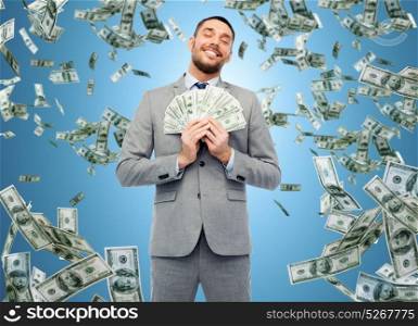 business, people and finances concept - smiling businessman with bundle of american dollar cash money over blue background. smiling businessman with american dollar money