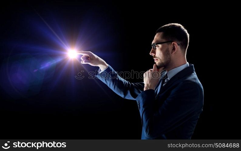business, people and future concept - businessman in suit over black background with light. businessman in suit with light over black. businessman in suit with light over black