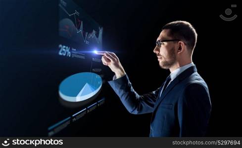 business, people and future technology concept - businessman in glasses working with virtual pie chart projection over black background. businessman working with virtual pie chart
