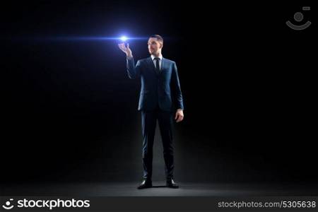 business, people and future technology concept - businessman in suit with laser light over black background. businessman with laser light over black
