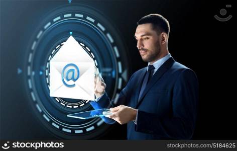business, people and future technology concept - businessman in suit working with transparent tablet pc computer and e-mail message hologram over black background. businessman with tablet pc and e-mail hologram