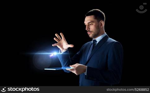 business, people and future technology concept - businessman in suit working with transparent tablet pc computer over black background. businessman in suit with transparent tablet pc