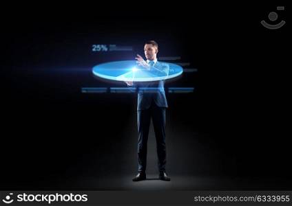 business, people and future technology concept - businessman in suit working with virtual pie chart projection over black background. businessman in suit working with virtual pie chart