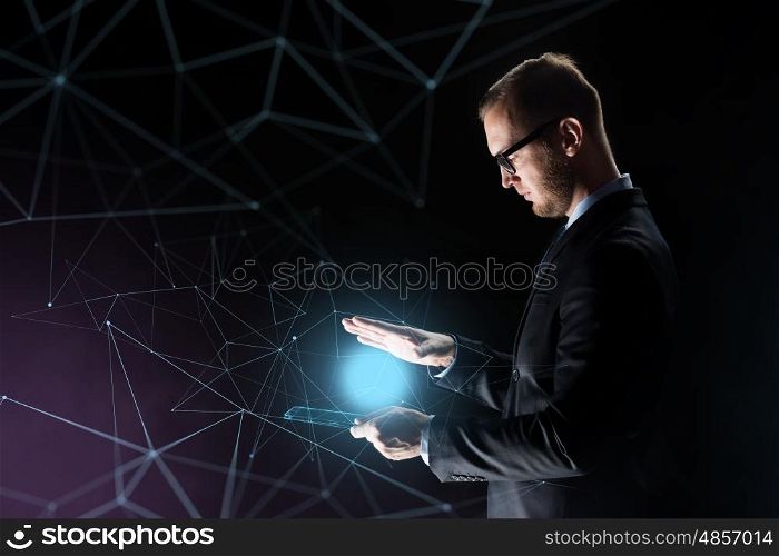 business, people and future technology concept - businessman with light above transparent tablet pc computer over dark background