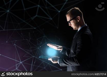 business, people and future technology concept - businessman with light above transparent tablet pc computer over dark background