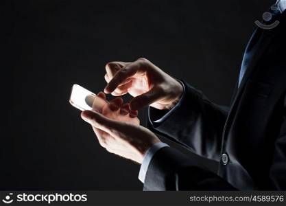 business, people and future technology concept - close up of businessman hands with transparent smartphone over black