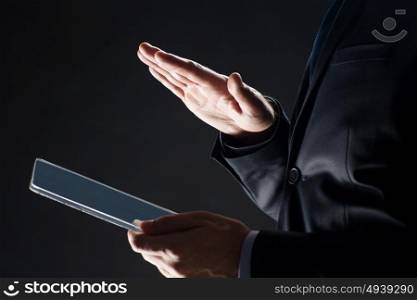business, people and future technology concept - close up of businessman hands with transparent tablet pc computer over black. close up of businessman with transparent tablet pc