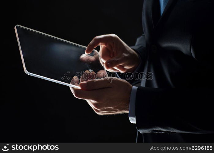 business, people and future technology concept - close up of businessman hands with transparent tablet pc computer over black. close up of businessman with transparent tablet pc