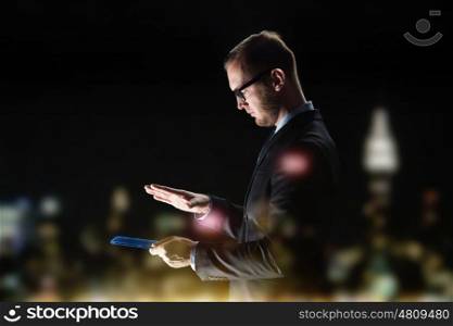 business, people and future technology concept - close up of businessman with transparent tablet pc computer over city lights and dark background