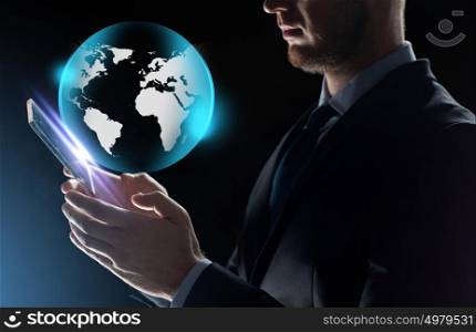 business, people and future technology concept - close up of businessman with transparent tablet pc computer and earth projection over black background. close up of businessman with transparent tablet pc