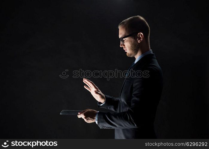business, people and future technology concept - close up of businessman with transparent tablet pc computer over black. close up of businessman with transparent tablet pc