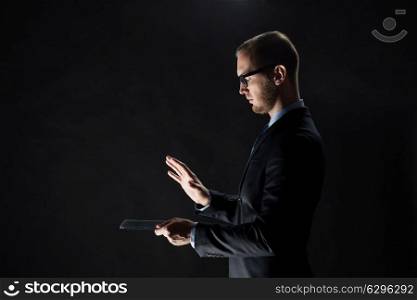 business, people and future technology concept - close up of businessman with transparent tablet pc computer over black. close up of businessman with transparent tablet pc