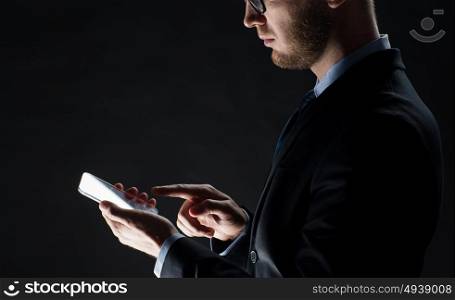business, people and future technology concept - close up of businessman with transparent smartphone over black. close up of businessman with glass smartphone