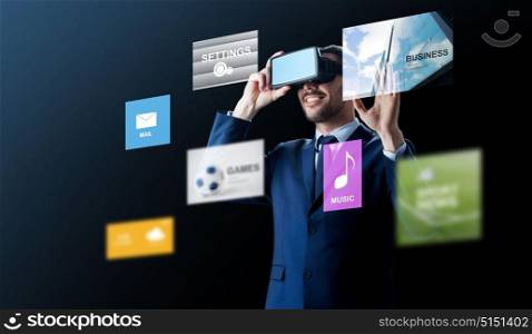 business, people and future technology concept - smiling businessman in headset over black background with virtual applications. businessman in virtual reality headset over black