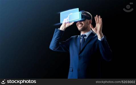 business, people and future technology concept - smiling businessman in headset over black background with virtual screen. businessman in virtual reality headset over black