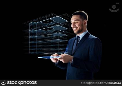 business, people and future technology concept - smiling businessman in suit working with transparent tablet pc computer and virtual construction hologram over black background. businessman with tablet pc and virtual building. businessman with tablet pc and virtual building