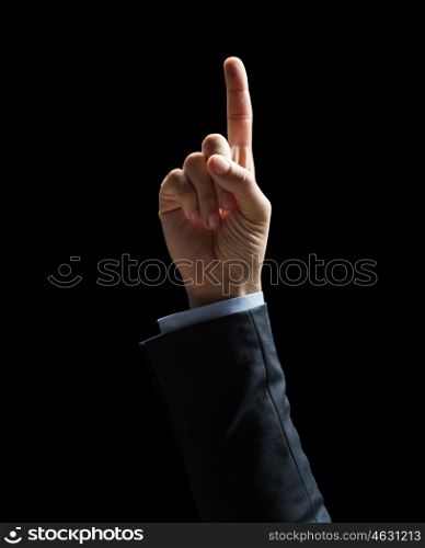 business, people and idea concept - close up of businessman hand pointing finger up over black background