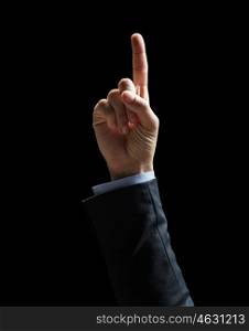 business, people and idea concept - close up of businessman hand pointing finger up over black background
