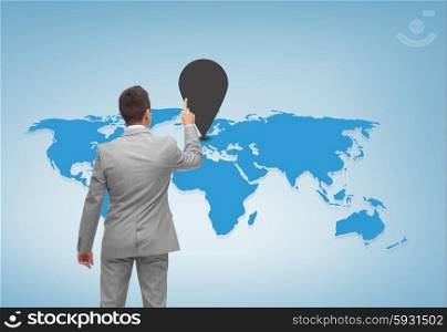 business, people and location concept - businessman pointing finger to mark on world map over blue background from back