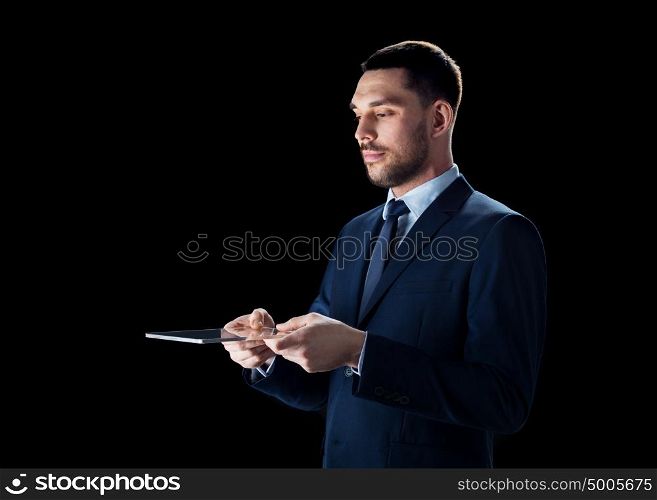 business, people and modern technology concept - businessman in suit working with transparent tablet pc computer over black background. businessman in suit with transparent tablet pc
