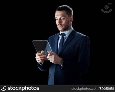 business, people and modern technology concept - businessman in suit working with transparent tablet pc computer over black background. businessman in suit with transparent tablet pc