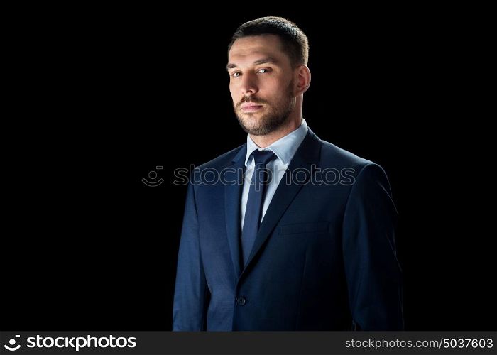 business, people and office concept - buisnessman in suit over black background. buisnessman in suit over black