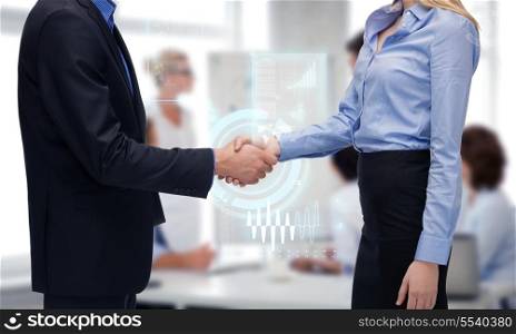 business people and office concept - businessman and businesswoman shaking their hands in office