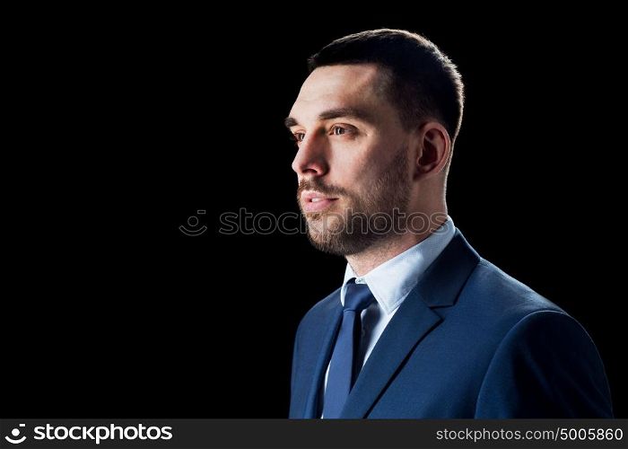 business, people and office concept - businessman in suit over black background. businessman in suit over black
