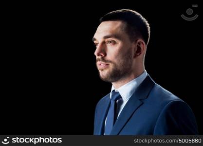 business, people and office concept - businessman in suit over black background. businessman in suit over black