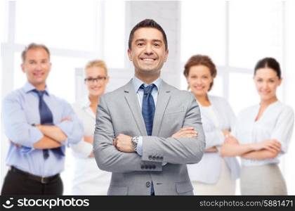 business, people and office concept - happy smiling business team over office room background