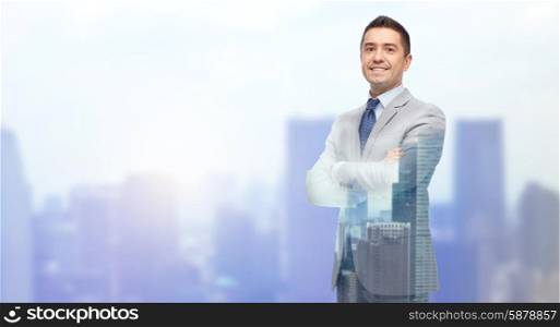 business, people and office concept - happy smiling businessman in suit over city background with double exposure