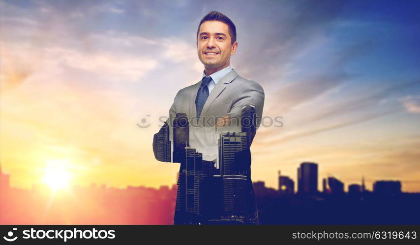 business, people and office concept - happy smiling businessman in suit over city and sun light background and double exposure. happy smiling businessman over city background