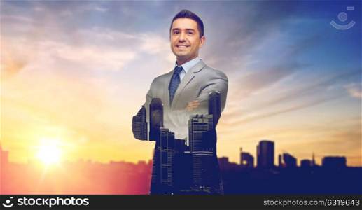 business, people and office concept - happy smiling businessman in suit over city and sun light background and double exposure. happy smiling businessman over city background