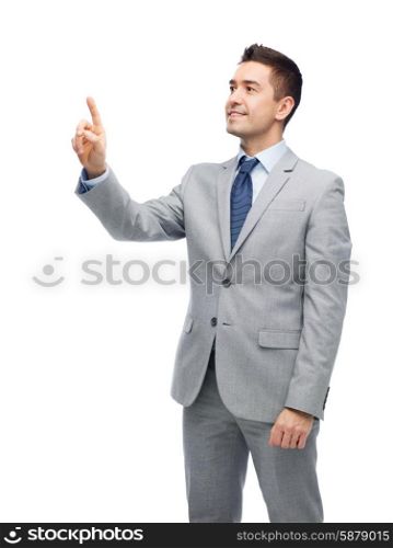 business, people and office concept - happy smiling businessman in suit touching something imaginary