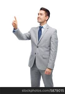 business, people and office concept - happy smiling businessman in suit touching something imaginary