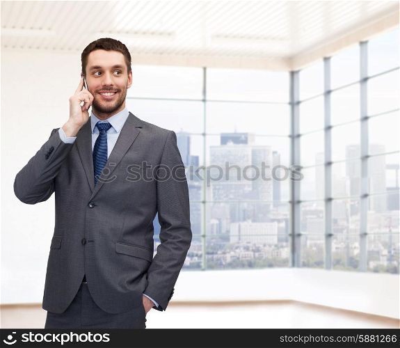business, people and office concept - happy young businessman calling on smartphone over office room or new apartment background