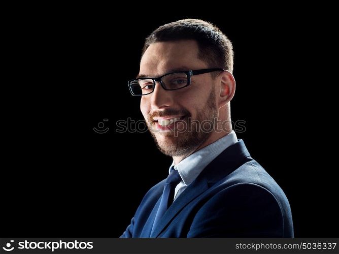 business, people and office concept - smiling businessman in glasses over black background. smiling businessman in glasses over black