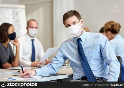 business, people and pandemic concept - businessman wearing face protective medical mask for protection from virus disease at office. businessman wearing face protective mask at office